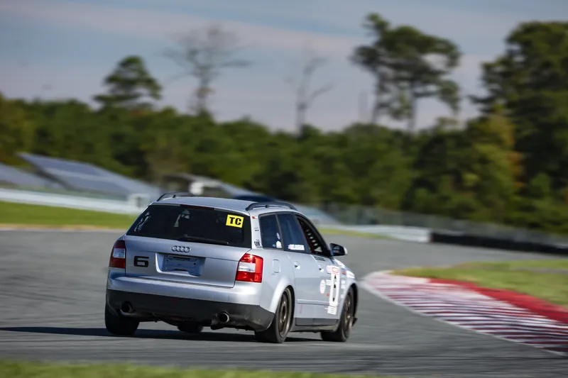 Rear view of Audi A4 Avant #6 accelerating toward a right-hand bend